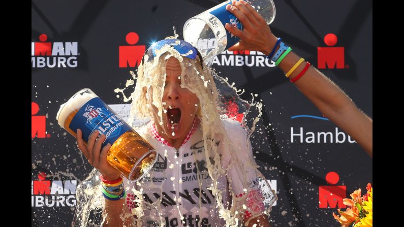 Sarah Crowley gets showered with beer after winning the women's race at IRONMAN Hamburg on Sunday, July 29, in Hamburg, Germany.  