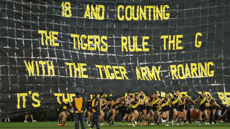 The Tigers run through their banner during the round 20 AFL match between the Richmond Tigers and the Geelong Cats at Melbourne Cricket Ground on Friday, August 3, in Melbourne, Australia. 