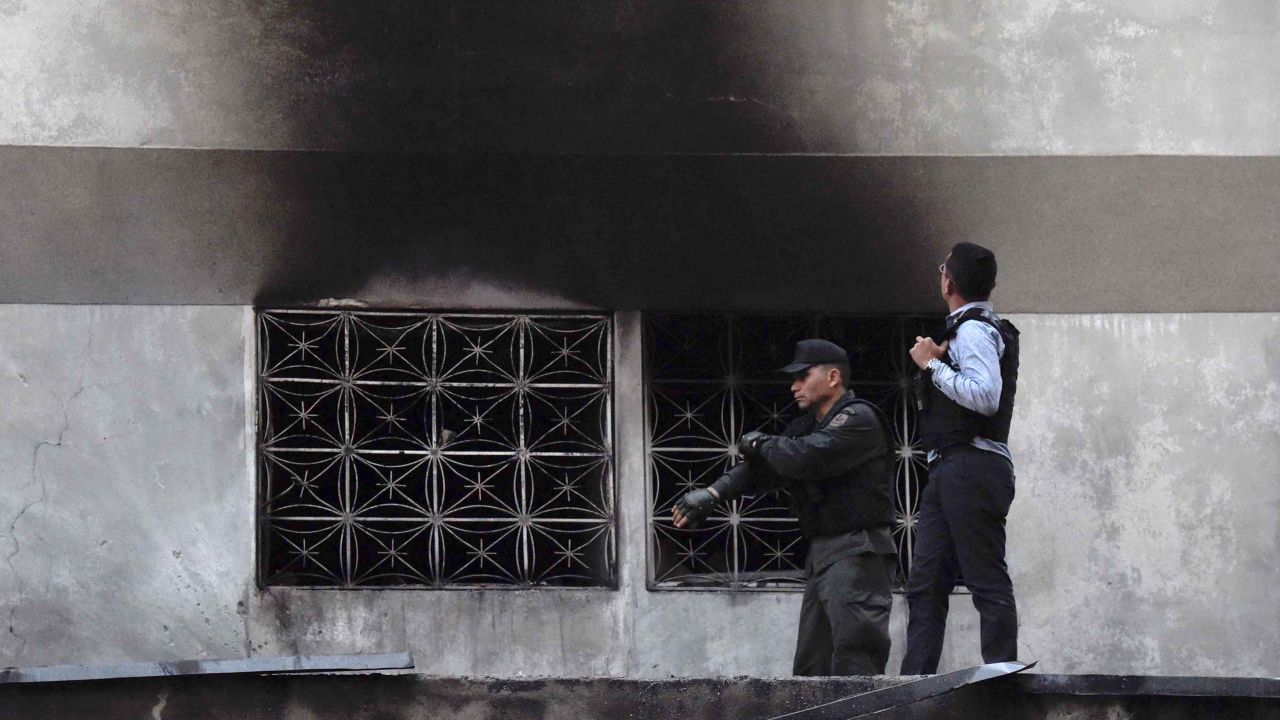 Security forces check a nearby building after an explosion was heard during Maduro's speech.