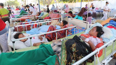 Patients in their beds are moved to an emergency tent outside of the Tanjung hospital, Lombok. 