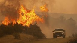 A truck passes by flames during the Ranch Fire in Clearlake Oaks, Calif., on Sunday, Aug. 5, 2018. (AP Photo/Josh Edelson)