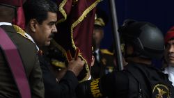 Venezuelan President Nicolas Maduro (L) attends a ceremony to celebrate the 81st anniversary of the National Guard in Caracas on August 4, 2018. - Maduro was unharmed after an exploding drone "attack", the minister of communication Jorge Rodriguez said following the incident, which saw uniformed military members break ranks and scatter after a loud bang interrupted the leader's remarks and caused him to look to the sky, according to images broadcast on state television. (Photo by Juan BARRETO / AFP)        (Photo credit should read JUAN BARRETO/AFP/Getty Images)