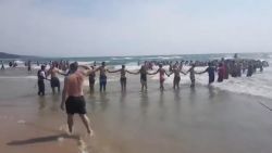 Beachgoers human chain