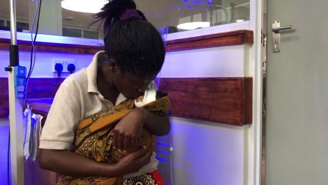 Lilian Matchaya holds her daughter, Abigail, praying for her to get better.