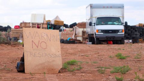 A "no trespassing" sign marks the outside of the compound.