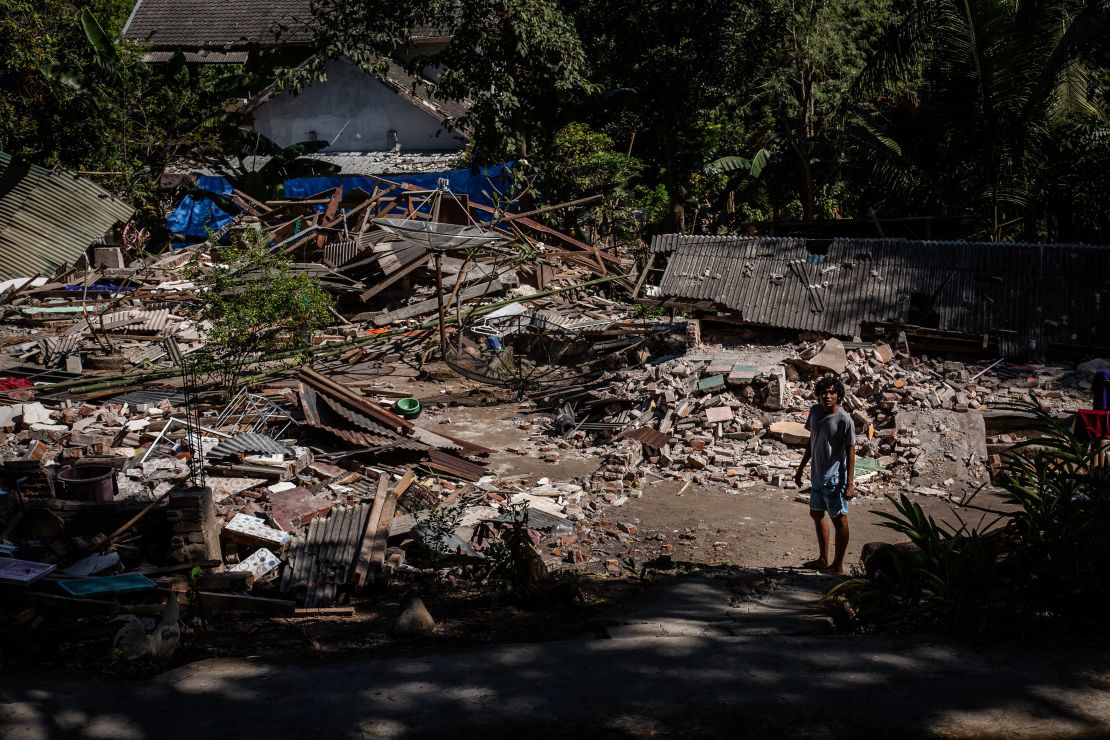 A man stands near the ruins of a collapsed house on Lombok island on Wednesday. 