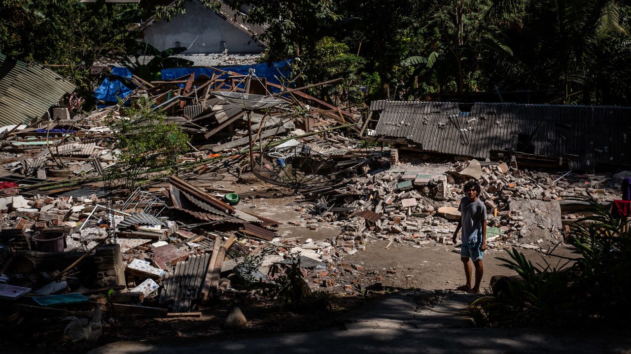 A man stands near the ruins of a collapsed house on Lombok island on Wednesday. 