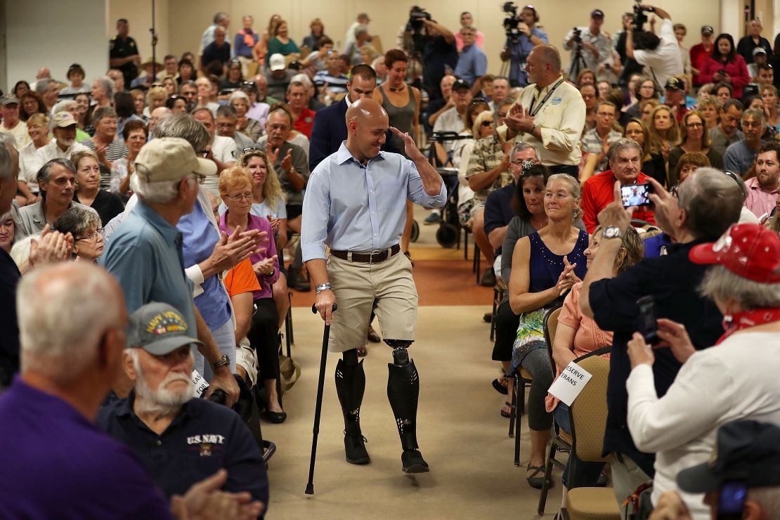 Rep. Brian Mast salutes as he arrives for a town hall meeting in Fort Pierce, Florida.