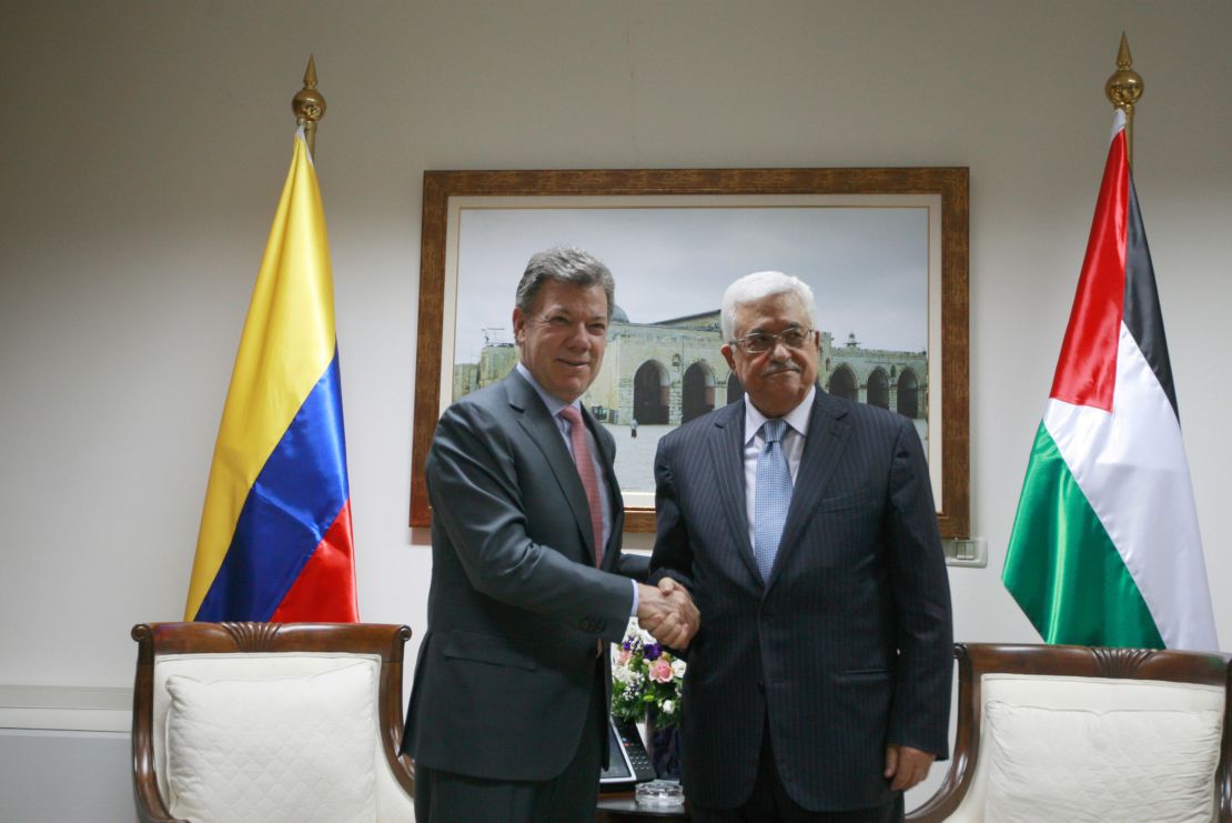Colombia's former President Juan Manuel Santos (L) poses with Palestinian Authority President Mahmoud Abbas during a 2013 meeting.