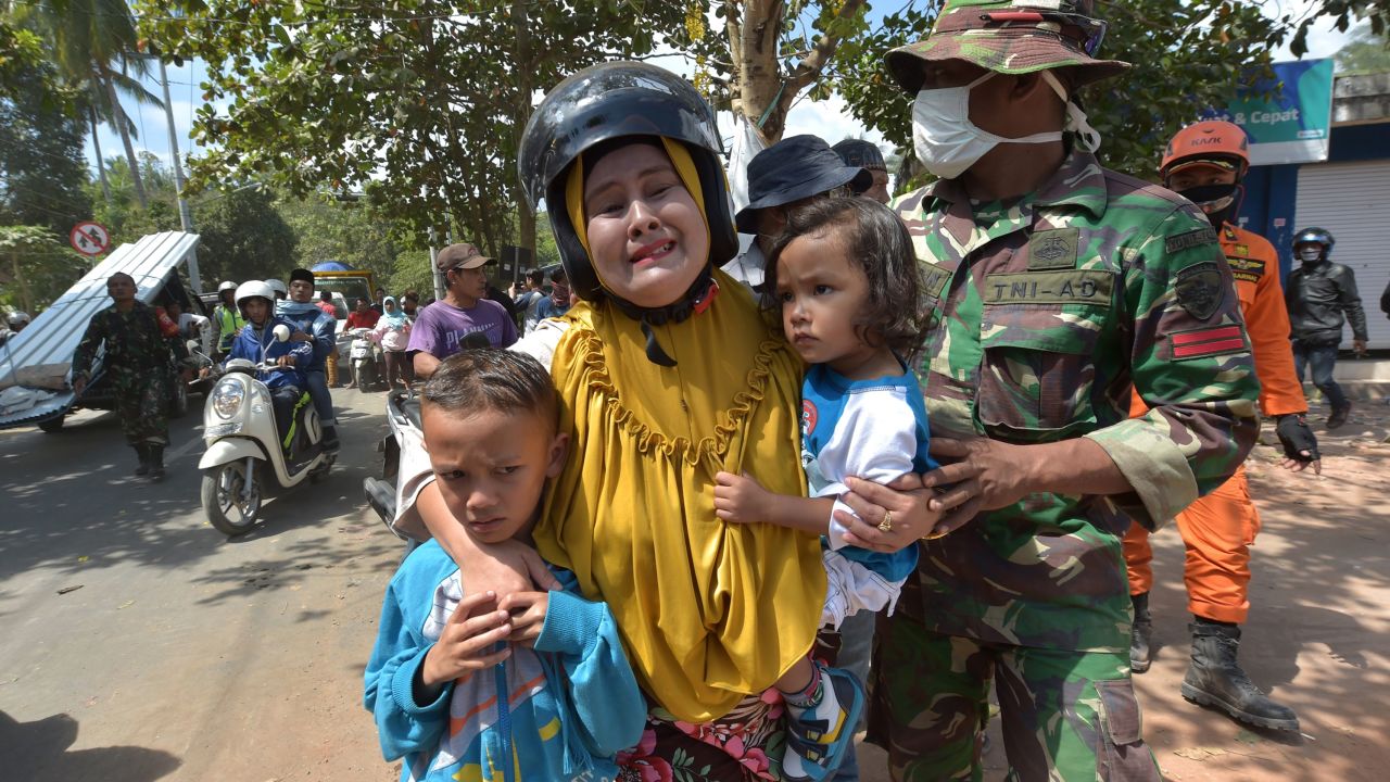 An Indonesian woman cries next to her childern shortly after an aftershock Thursday on Lombok.