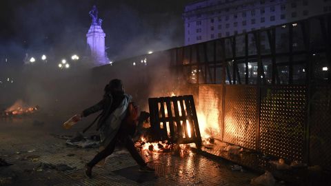 A woman throws a bottle outside the Congress early Thursday.