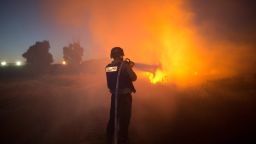 An Israeli firefighter extinguishes fire after rockets fired by Palestinian militants from the Gaza strip hit a field near the southern Israeli city of Sderot on August 20, 2014. Israel and Palestinian militants resumed fire across the Gaza border, sparking panic across the war-torn enclave and halting truce talks. Menahem Kahana/AFP/Getty Images