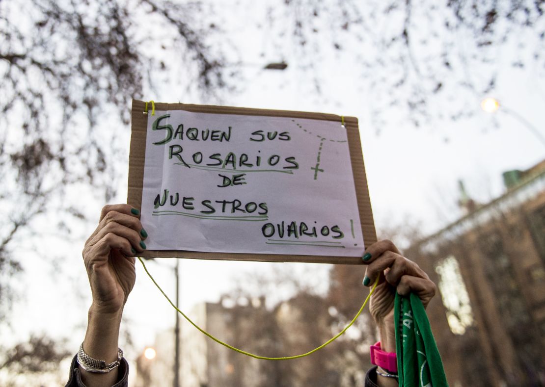 An activist in favor of legalizing abortion holds a sign reading "Take your Rosaries from our ovaries" during a demonstration outside of Argentina's embassy in Santiago, Chile.