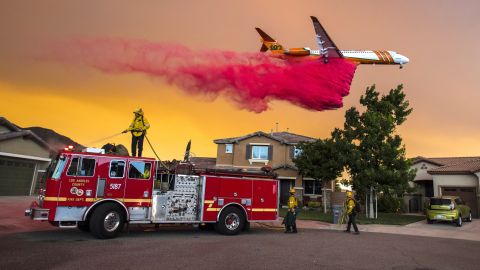 A plane drops fire retardant behind homes as the Holy Fire burns in Lake Elsinore on Wednesday, August 8.