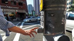BOSTON, MA - JULY 21: A pedestrian presses a traffic signal button at Congress and Sudbury Streets in Boston on Jul. 21, 2017. The vast majority of these buttons that dot downtown neighborhoods don't actually do anything. Thats by design. Officials say the citys core is just too congested  with cars and pedestrians  to allow any one person to manipulate the cycle. (Photo by David L. Ryan/The Boston Globe via Getty Images)