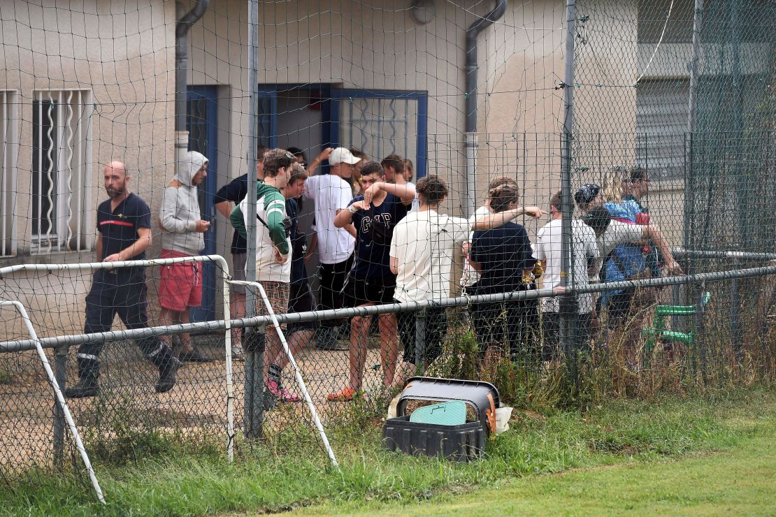 German teenagers from a summer camp stand in front of a rescue center after being evacuated from a flooded campsite.