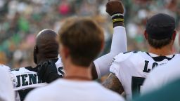 Malcolm Jenkins #27 of the Philadelphia Eagles raises his fist during the national anthem as Chris Long #56 puts his arm around him prior to a preseason game. Mitchell Leff/Getty Images