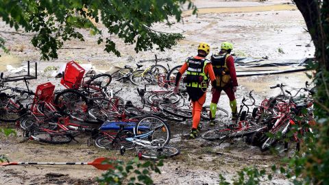Rescuers walk past damaged bicycles in a flooded camping area on August 9 in Saint-Julien-de-Peyrolas in southern France.