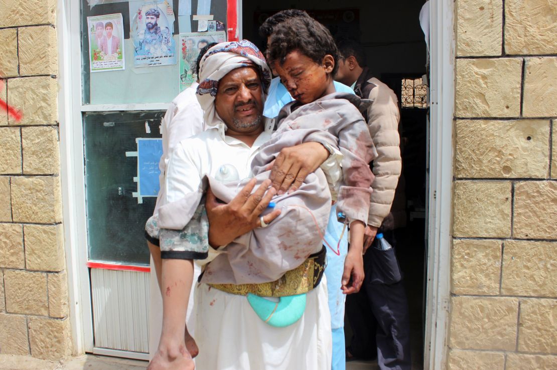 A man transports a child to a hospital after he was wounded Thursday in the strike in northern Yemen.