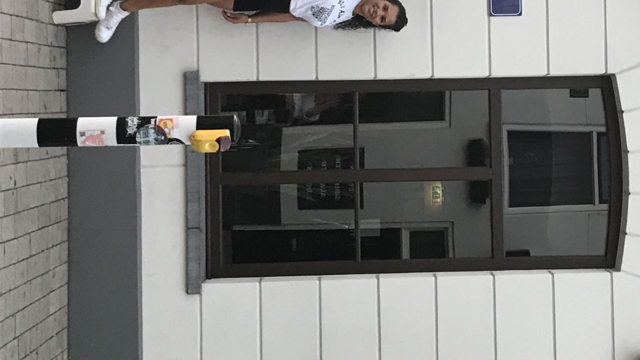 Activist Naomi Zaloumis pointing to one of the new signs