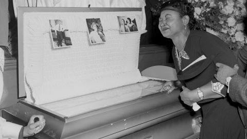 Emmett Till's mother grieves over his casket, which was donated after the boy's remains were exhumed and reburied.