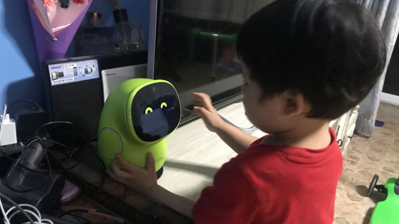Three-year-old Seven Kong plays with the android, named BeanQ. 