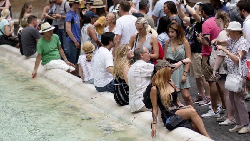 Tourists cool themselves in the water of the Trevi Fountain in central Rome on July 14, 2018, as Italy is experiencing its first Summer heat wave with temperatures approaching 40 degrees Celsius. (Photo by Andreas SOLARO / AFP)        (Photo credit should read ANDREAS SOLARO/AFP/Getty Images)