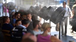 Fans spray water on clients on the terrace of the bar of the Circulo de Bellas Artes building during a heatwave in Madrid on June 15, 2017. / AFP PHOTO / GERARD JULIEN        (Photo credit should read GERARD JULIEN/AFP/Getty Images)