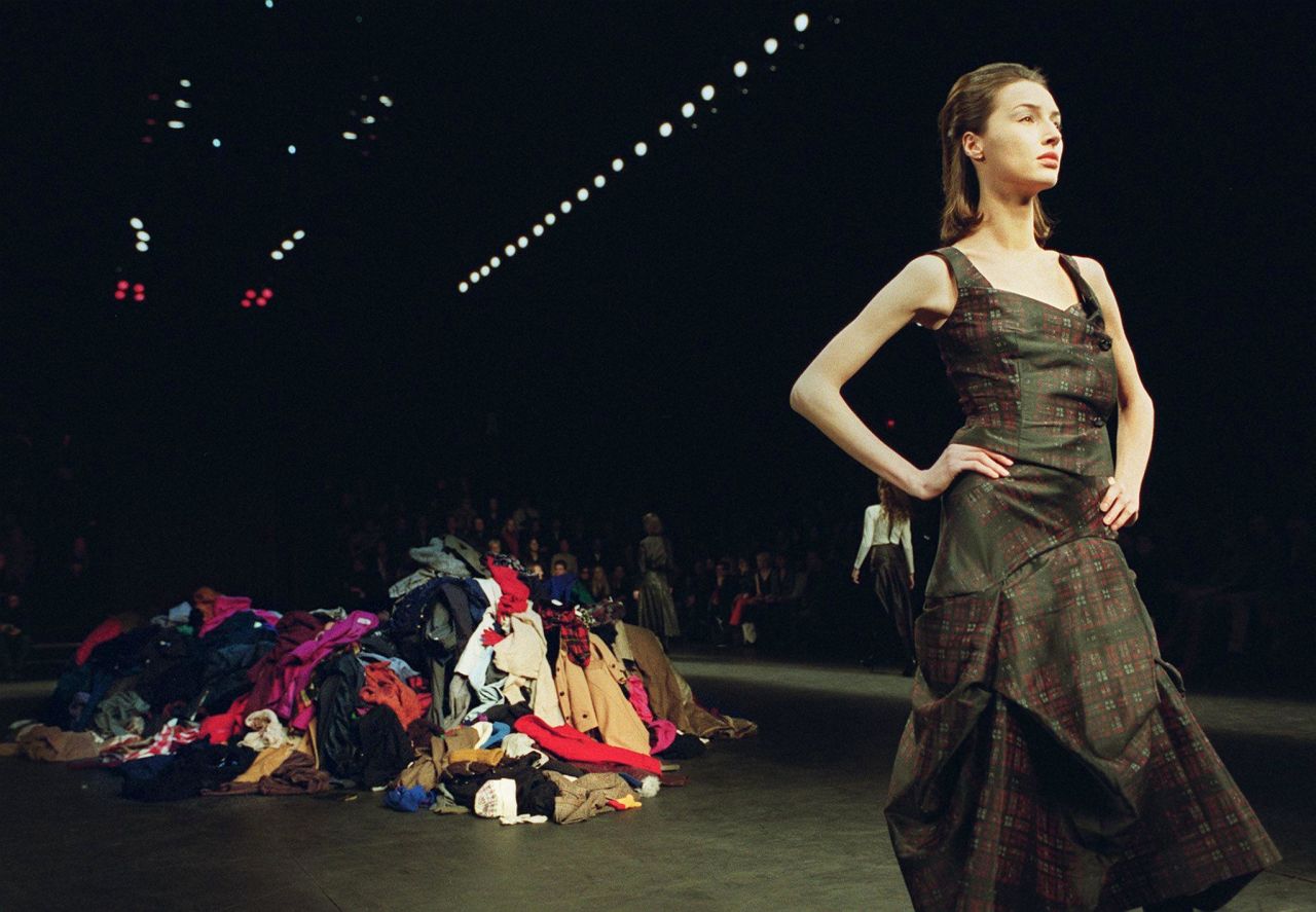 A model poses in front of a pile of clothes at the Vivienne Westwood Autumn-Winter 2000 show.