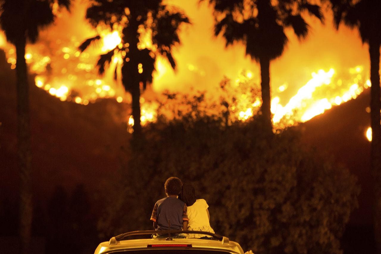 King Bass, 6, and his 5-year-old sister, Princess, watch the Holy Fire burn from the top of their parents' car in Lake Elsinore on Thursday, August 9.