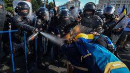 Romanian police scuffle with protesters and spray tear gas against them during an anti-government protest in front of the Romanian Government headquarters in Bucharest August 10, 2018. (Photo by Daniel MIHAILESCU / AFP)        (Photo credit should read DANIEL MIHAILESCU/AFP/Getty Images)