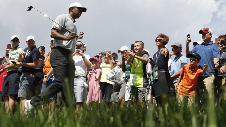 Tiger Woods walks past spectators on his way to the eighth tee during the second round of the PGA Championship golf tournament on Friday, August 10, outside of St. Louis. 