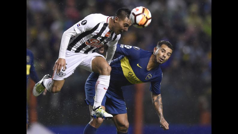 Angel Lucena of Paraguay's Libertad, left, heads the ball alongside Edwin Cardona of Argentina's Boca Juniors during a Copa Libertadores soccer match in Buenos Aires on Wednesday, August 8. 