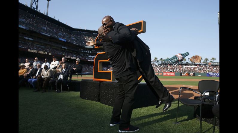 Former San Francisco Giants player Barry Bonds, right, is lifted up by former Pittsburgh Pirates teammate Bobby Bonilla at a ceremony to retire Bonds' jersey number before a baseball game between the Giants and the Pirates in San Francisco, on Saturday, August 11. 