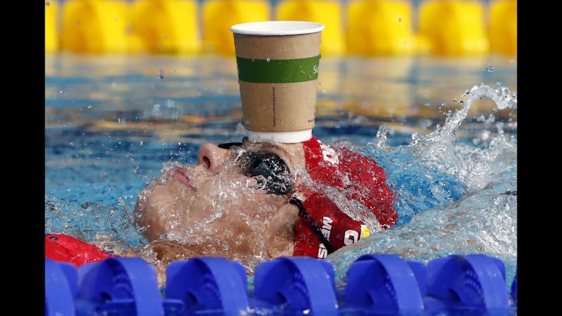 German swimmer Jenny Mensing balances a paper cup on her head as she warms up for a race at the European Championships on Thursday, August 6.