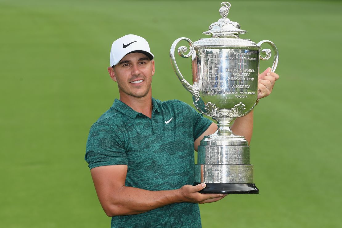 Brooks Koepka poses with the Wanamaker Trophy on the 18th green. 