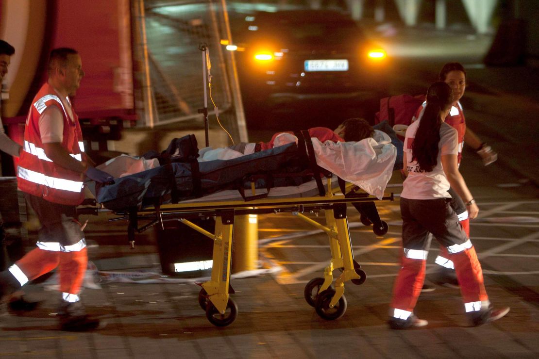 Red Cross paramedics transport an injured person to the hospital after the platform collapsed late Sunday night.