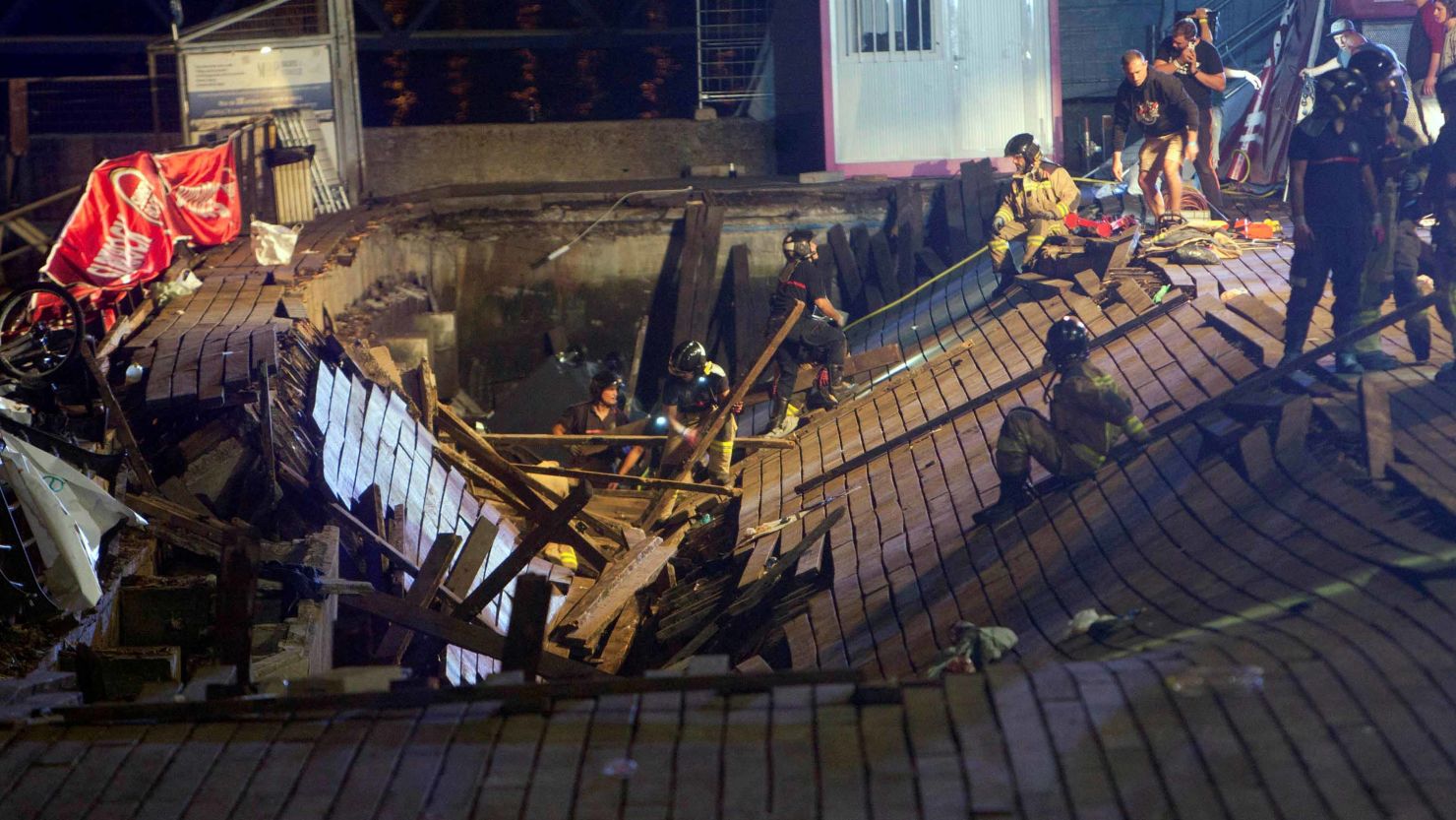 Firefighters search for victims after a wooden platform collapsed during a concert in Vigo late Sunday.