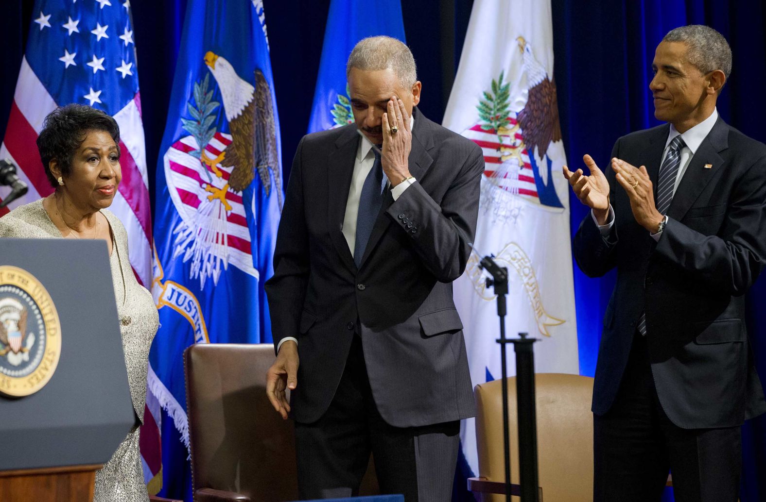 An emotional Attorney General Eric Holder, center, and President Barack Obama react after Franklin finished singing a song for Holder at an event celebrating the end of his tenure at the Department of Justice in 2015. 