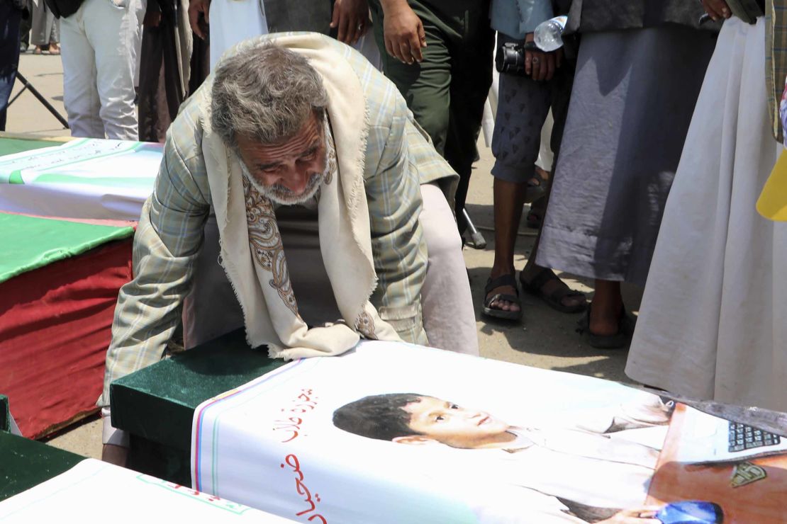 A Yemeni man mourns over a casket of one of the boys, during Monday's funeral.