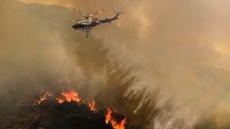 A helicopter drops water to a brush fire at the Holy Fire in Lake Elsinore, California, southeast of Los Angeles, on August 11, 2018. - The fire has burned 21,473 acres and was 29 percent contained as of 8:30 a.m. Saturday, according to the Cleveland National Forest. (Photo by RINGO CHIU / AFP)        (Photo credit should read RINGO CHIU/AFP/Getty Images)
