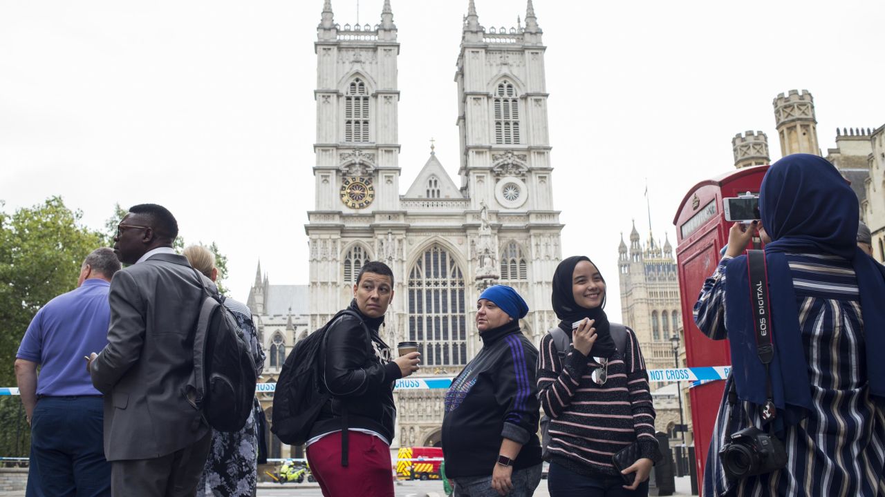 Siti Atikah Binti ABD Razak, 19, second from right, is photographed by her sister, Siti Nadhirah Binti ABD Razak, 21 (far right with back turned) outside Westminster Abbey, which was not accessible due to the ongoing police investigation.