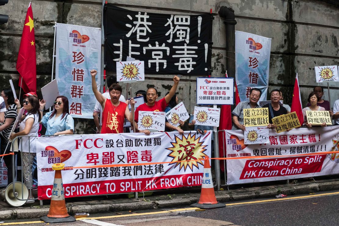 Pro-China protesters hold banners during a demonstration outside the Foreign Correspondents' Club in Hong Kong, on August 14, 2018.