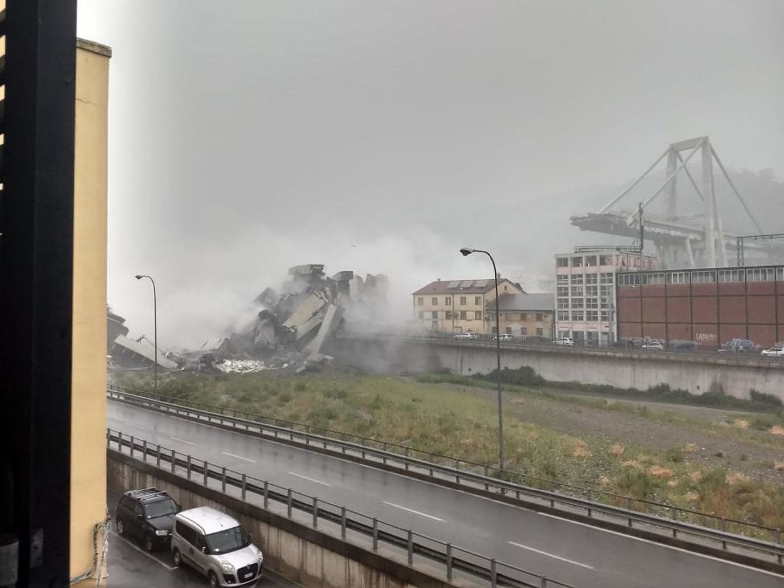 The rubble from the collapsed portion of the bridge is seen from afar.