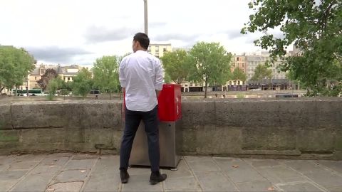 A man uses the newly-installed open air urinal in Paris.