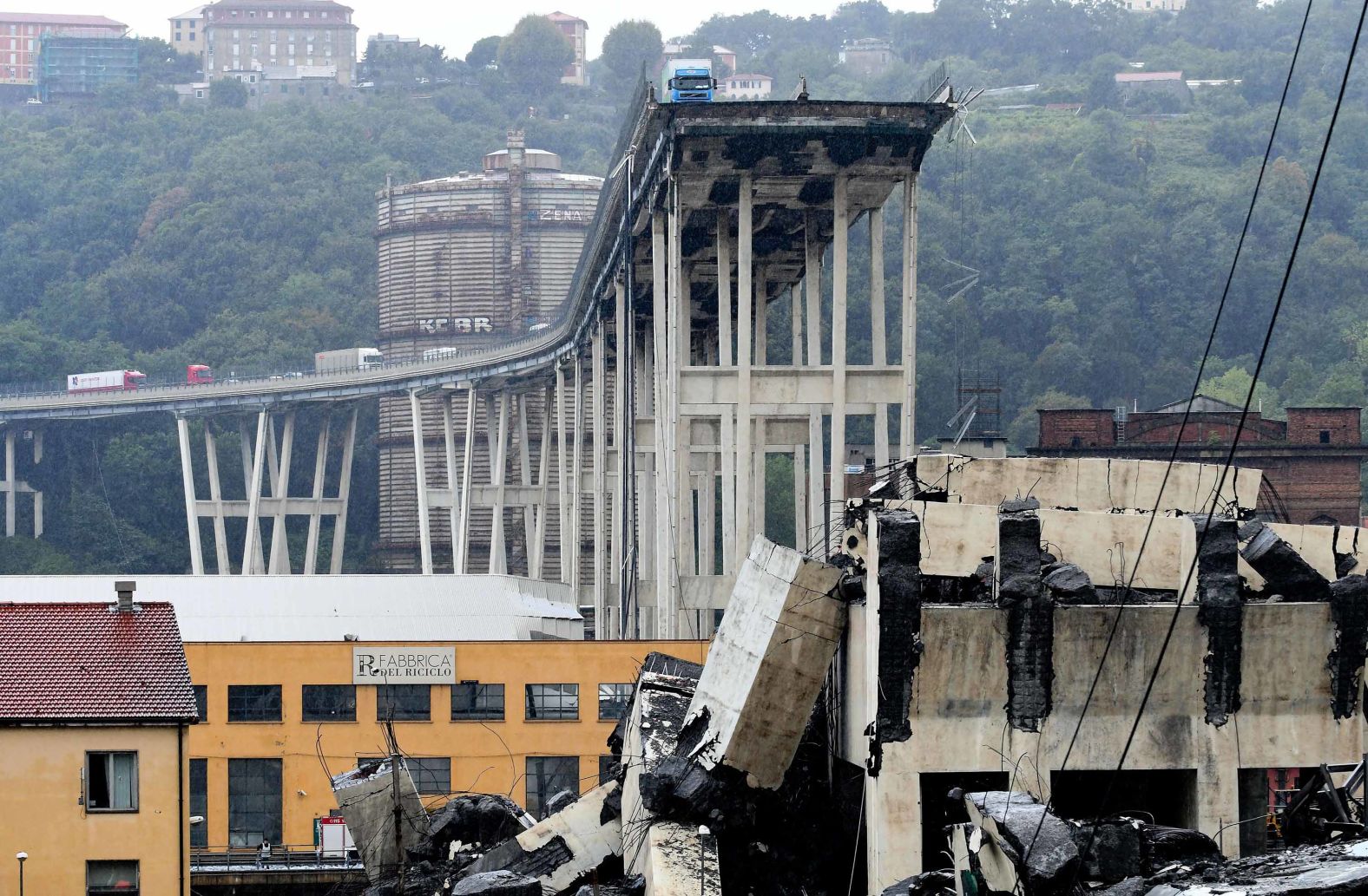 Vehicles line a part of the bridge that remains standing.