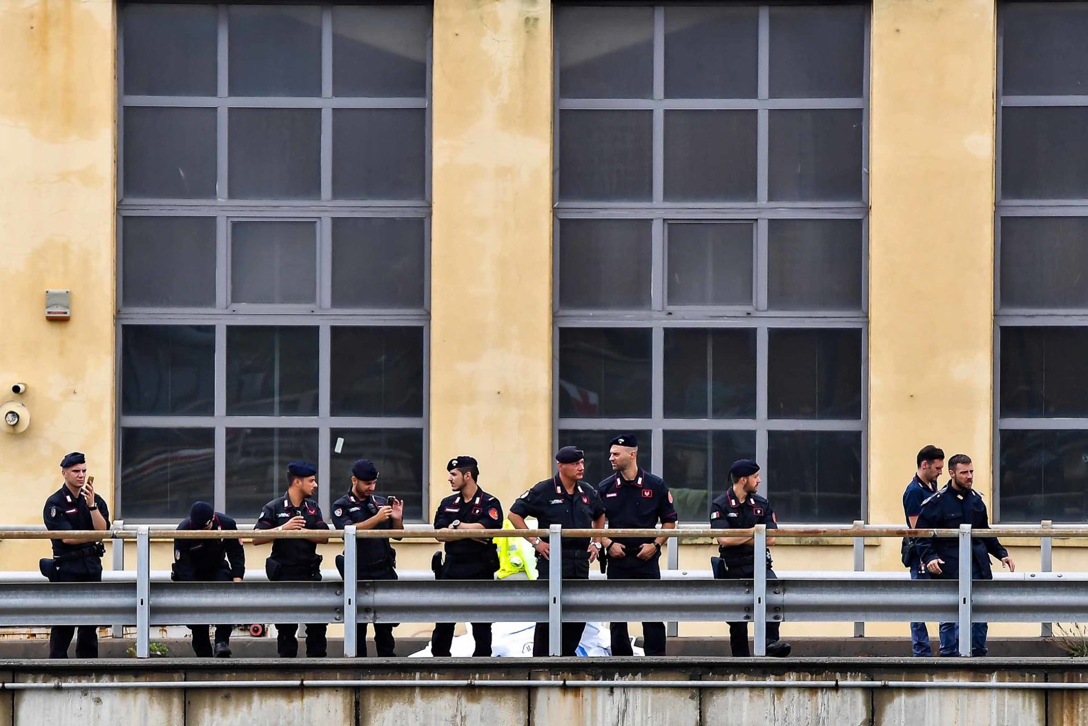 Police officers look on near the stricken bridge,