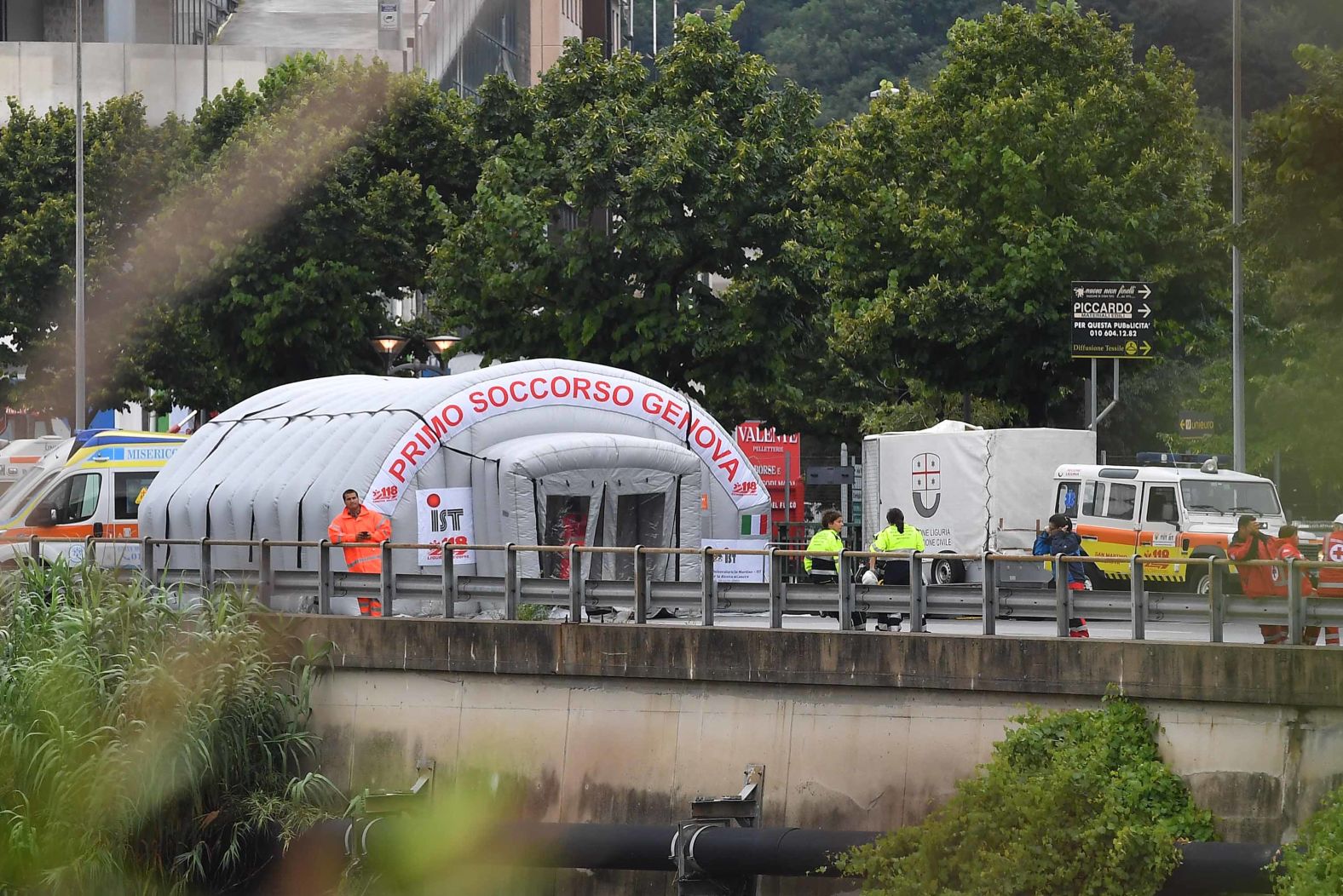 A Red Cross first aid tent is set up at the disaster scene.