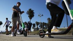 LOS ANGELES, CA - AUGUST 13:  People ride Lime shared dockless electric scooters along Venice Beach on August 13, 2018 in Los Angeles, California. Shared e-scooter startups Bird and Lime have rapidly expanded in the city. Some city residents complain the controversial e-scooters are dangerous for pedestrians and sometimes clog sidewalks. A Los Angeles Councilmember has proposed a ban on the scooters until regulations can be worked out.  (Photo by Mario Tama/Getty Images)