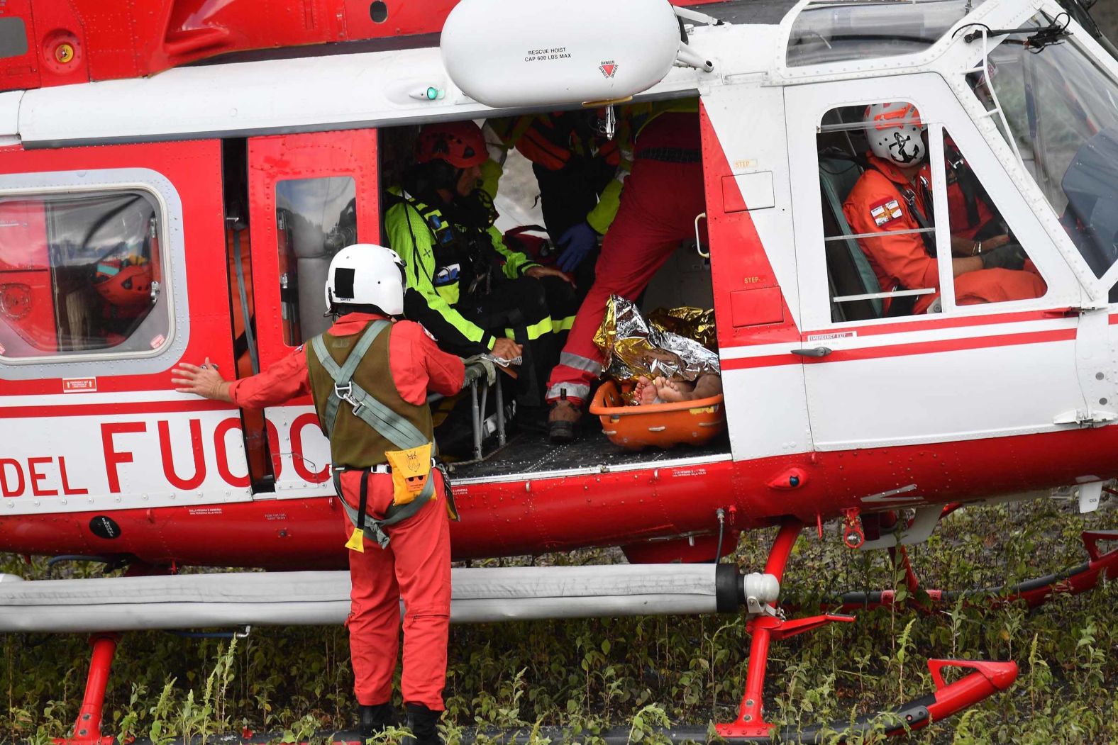 Firefighters prepare to transport an injured person from the site of the Morandi Bridge collapse.